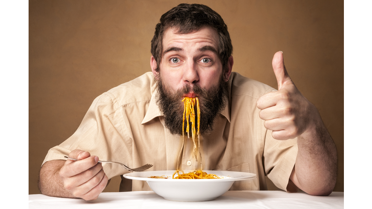 funny man with beard eating noodles