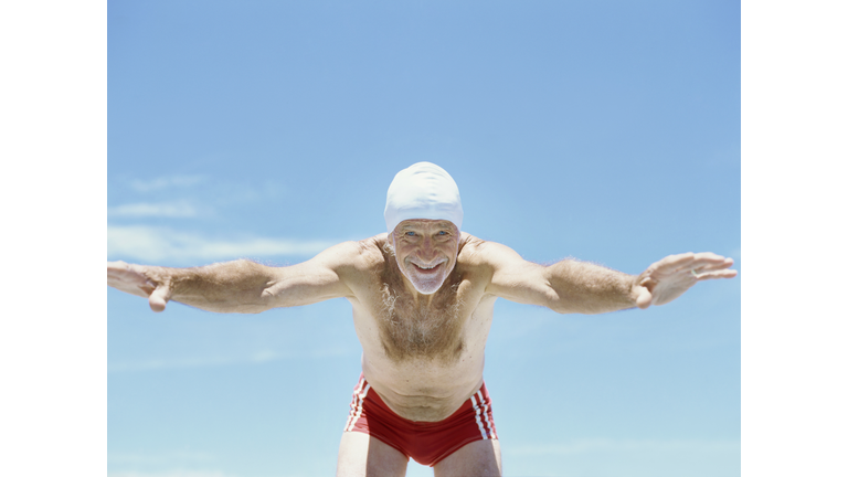 Senior man diving into swimming pool