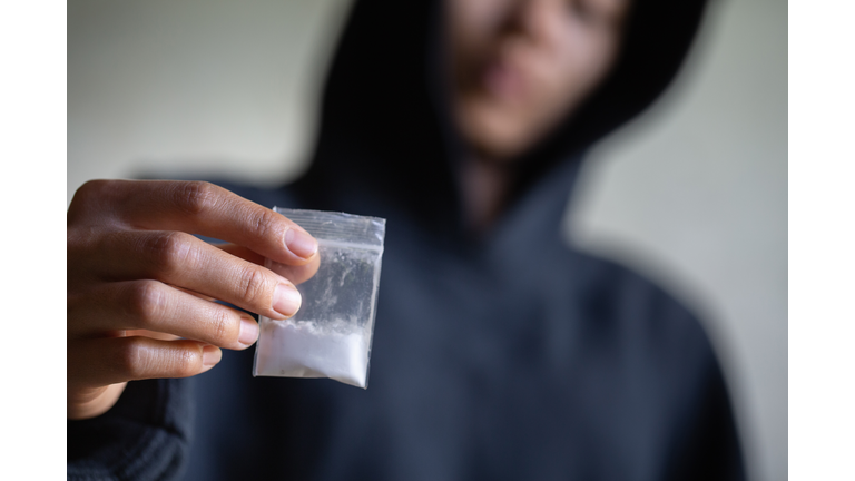 Hand of addict man holding cocaine or heroine, close up of addict buying dose from drug dealer, drug trafficking, crime, addiction and sale concept,