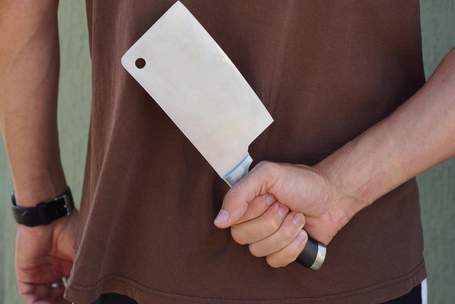 a man in  holds a large cleaver in his hand
