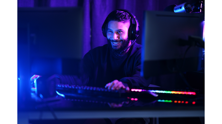 Cheerful gamer guy playing online games for relaxation