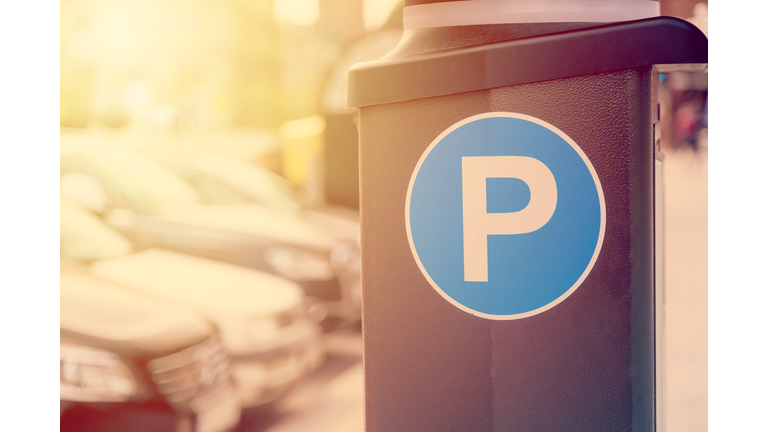 Blue parking sign with blurred cars in the background in Stockholm, Sweden. Toned image