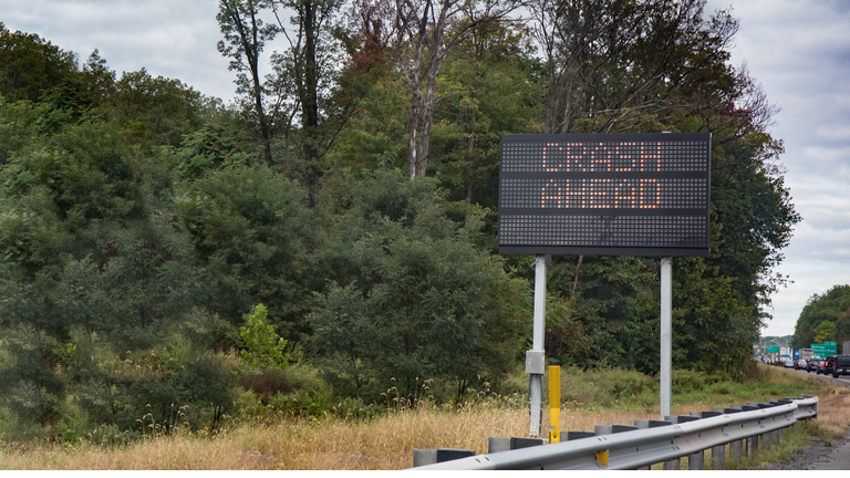 An electric sign warning motorists of a crash ahead with traffic backed up.