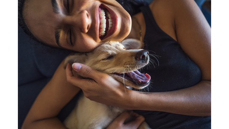 Beautiful young woman playing with a puppy