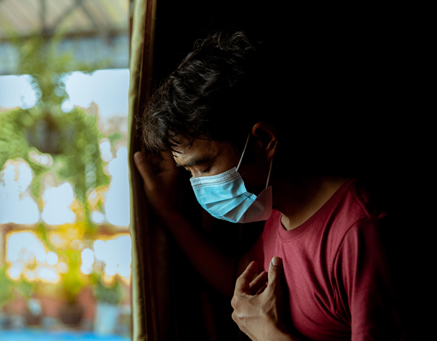 An Asian man wearing a mask has a side effect after suffering from COVID-19.