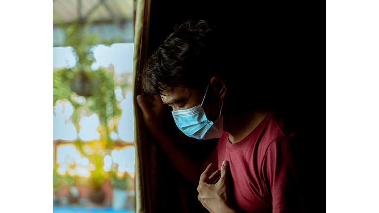 An Asian man wearing a mask has a side effect after suffering from COVID-19.