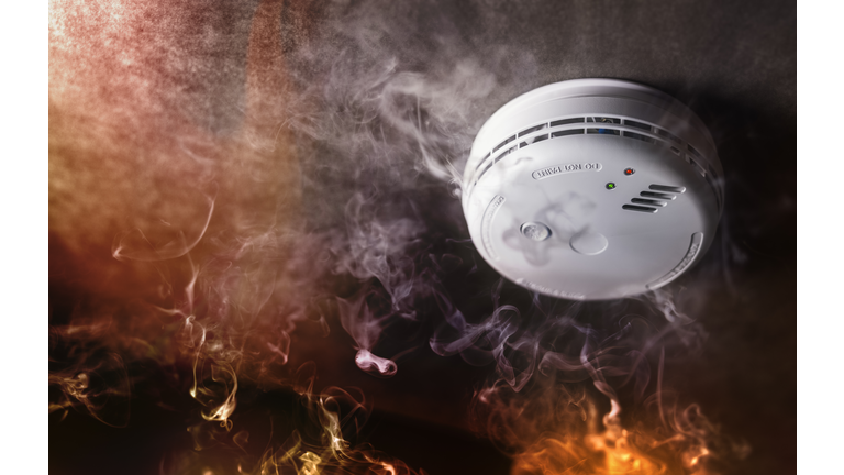 Smoke detector and fire alarm in action background