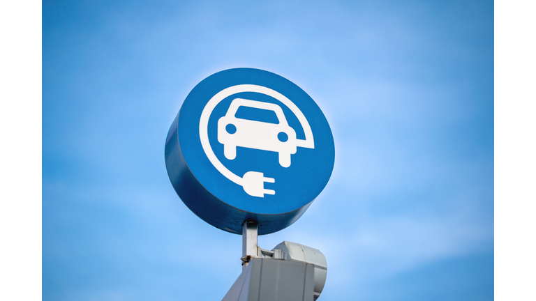 electric vehicle charging sign, blue sky background
