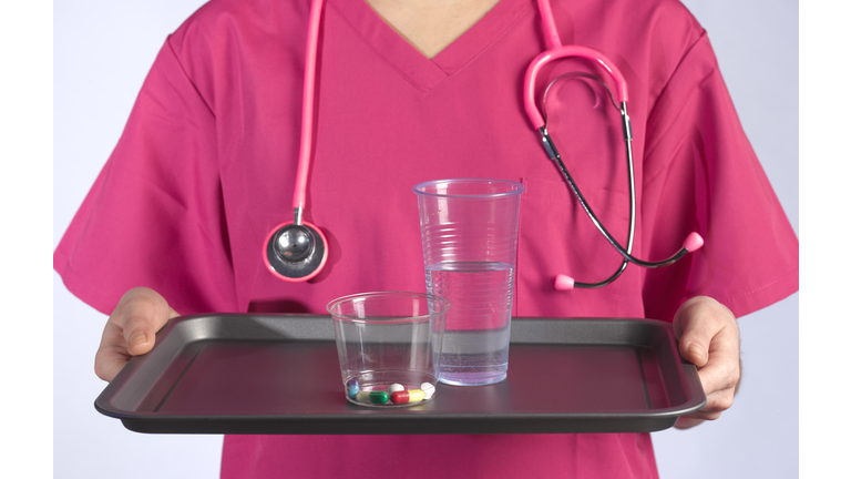 HOSPITAL NURSE CARRYING MEDICATION ON TRAY