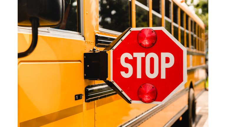 Yellow school bus. Stop sign. Be careful, schoolchildren crossing the road. New academic year semester. Welcome back to school. Lockdown, distance remote education learning