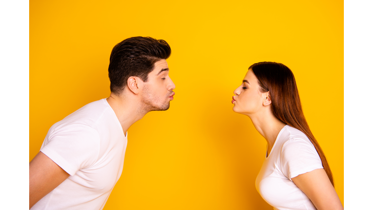 Close up side profile photo amazing beautiful she her he him his guy lady bonding ahead each other need kisses tenderness spread lips wear casual white t-shirts outfit isolated yellow background