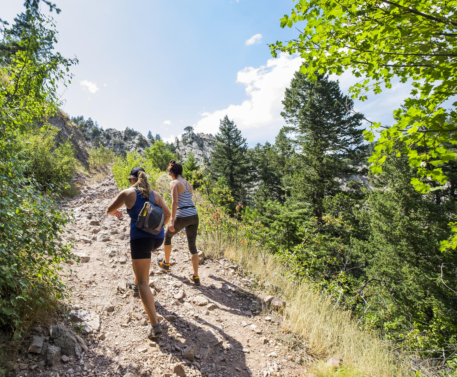 Two Women Hiking up a Mountain Trail.