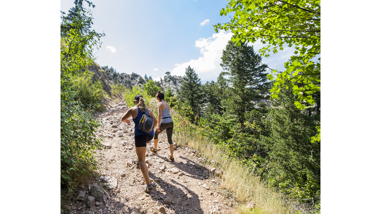 Two Women Hiking up a Mountain Trail.