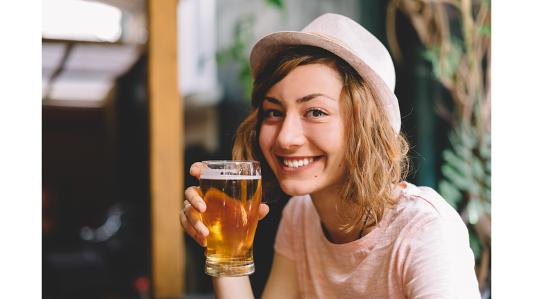 Smiling woman holding a pint of beer