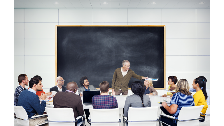 Multi-ethnic students gathered around professor
