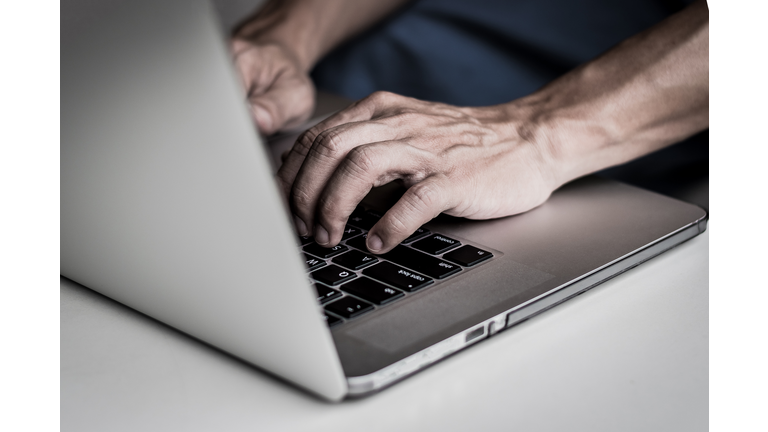 Hands of man user using computer notebook laptop typing on keyboard with dark beware tone for malware, ransomeware, scam, Virus ,Spyware, Malware, Antivirus, cyber attacks Concept. Data Privacy Day