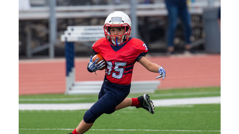 Athletic Young Boy Playing in a Football Game