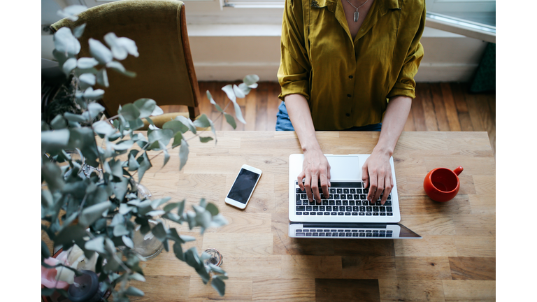 Overhead image of a female blogger writing on the laptop