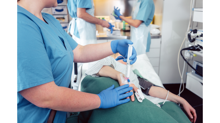 Nurse giving anesthesia to patient waiting for endoscopy