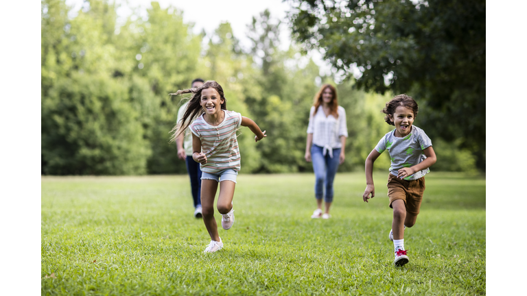 Brother and sister running in the park