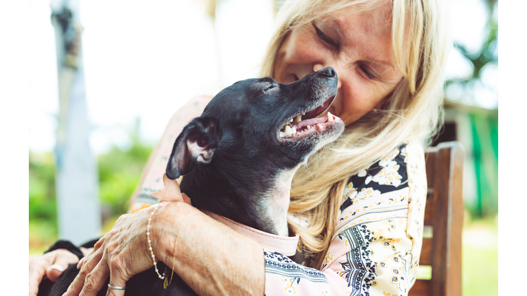 Senior woman hugging her small pet dog