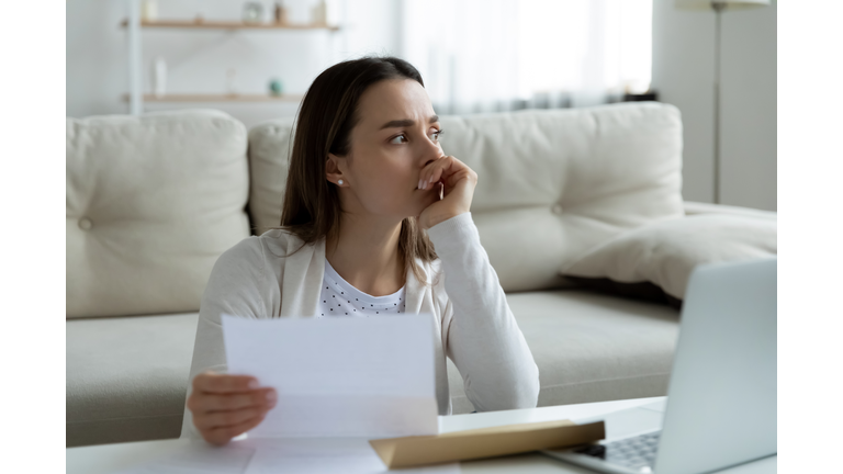 Frustrated young woman thinking of financial problems.