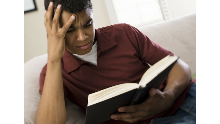 Close-up of a young man reading a book