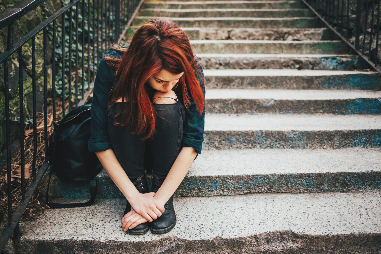 Sad lonely girl sitting on stairs