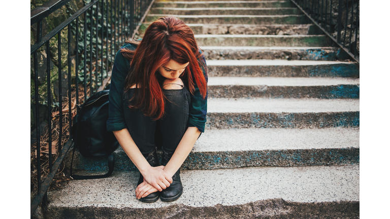 Sad lonely girl sitting on stairs