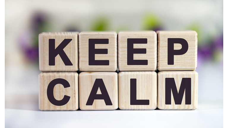 KEEP CALM - text on wooden cubes on a floral background with tulip buds