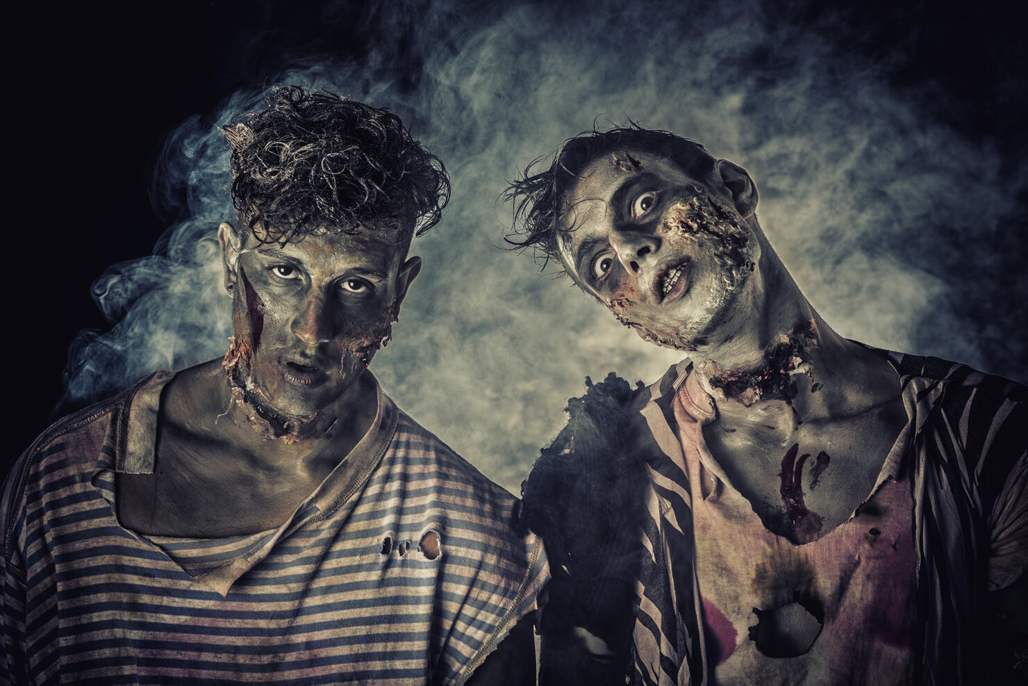 Two male zombies standing on black smoky background