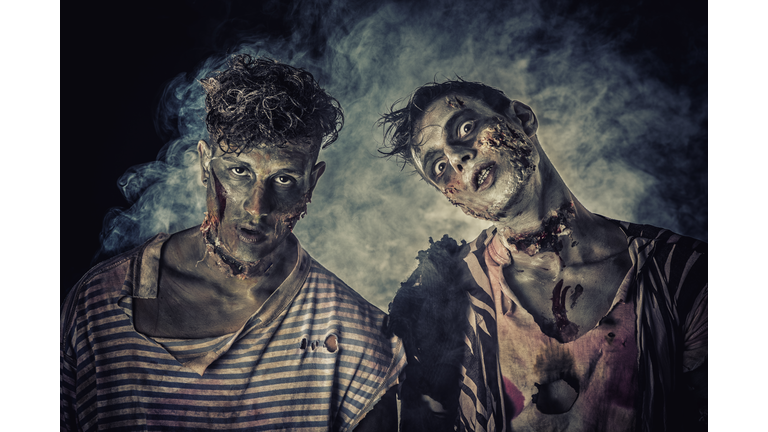 Two male zombies standing on black smoky background