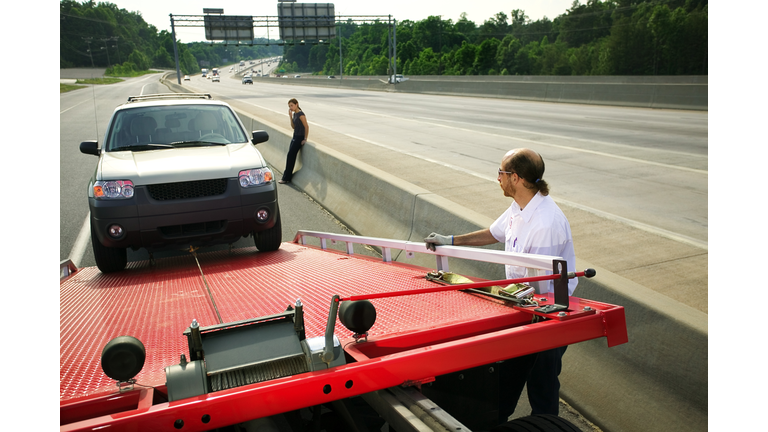 Tow truck driver loading car