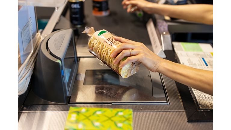 Sales clerk scanning the products at supermarket checkout