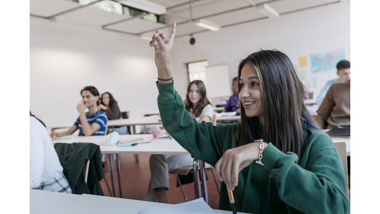 High School Student Raising Her Hand In Class