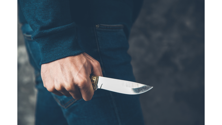 man hand holding knife on abstract background