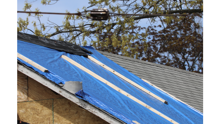 Building repair project with plastic tarp covering the roof