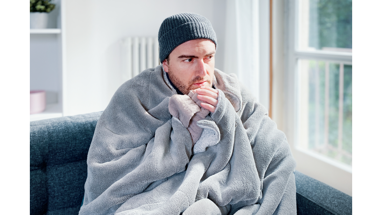 Man feeling cold at home with home heating trouble