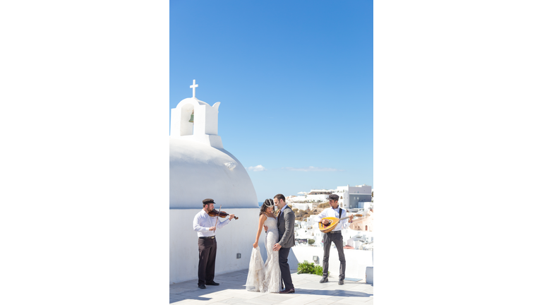 Bride and groom dansing on wedding ceremony on Santorini island, Greece.