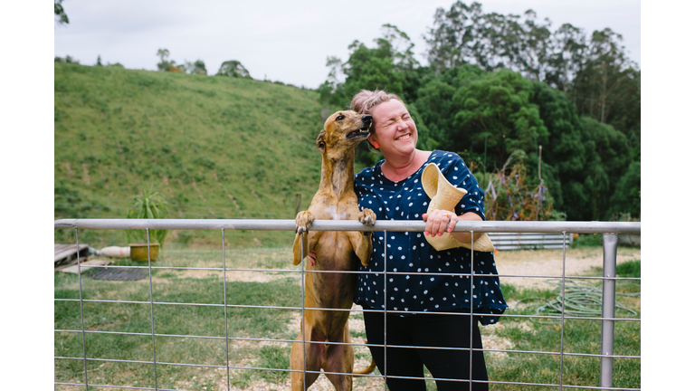 Portrait of mature woman laughing on a rural property with dog