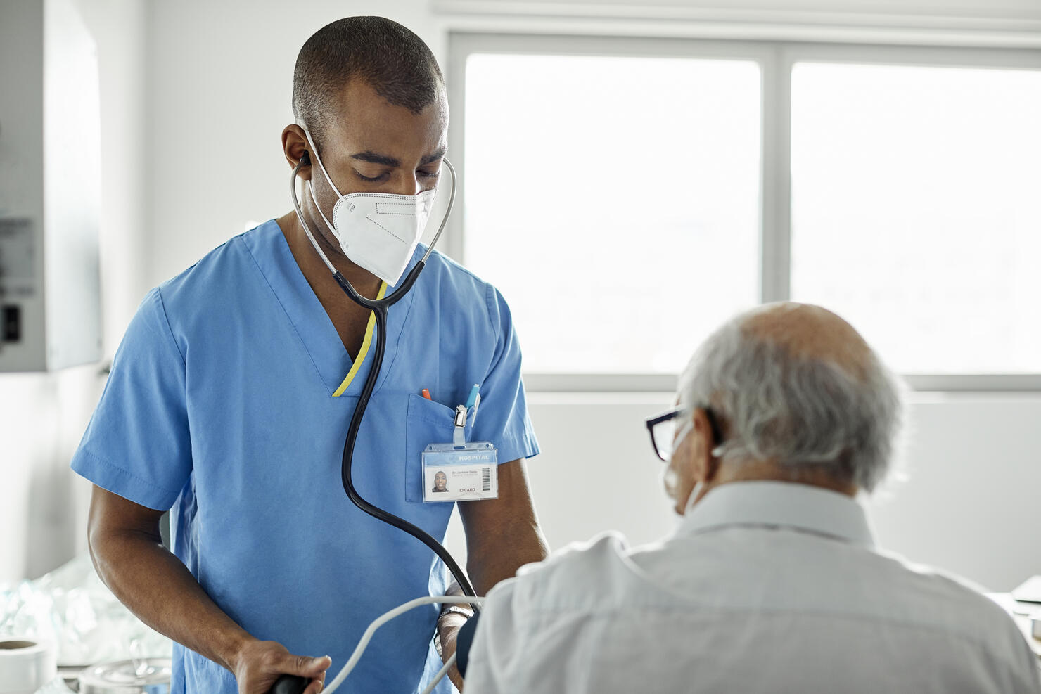 Nurse examining patient in clinic during COVID-19