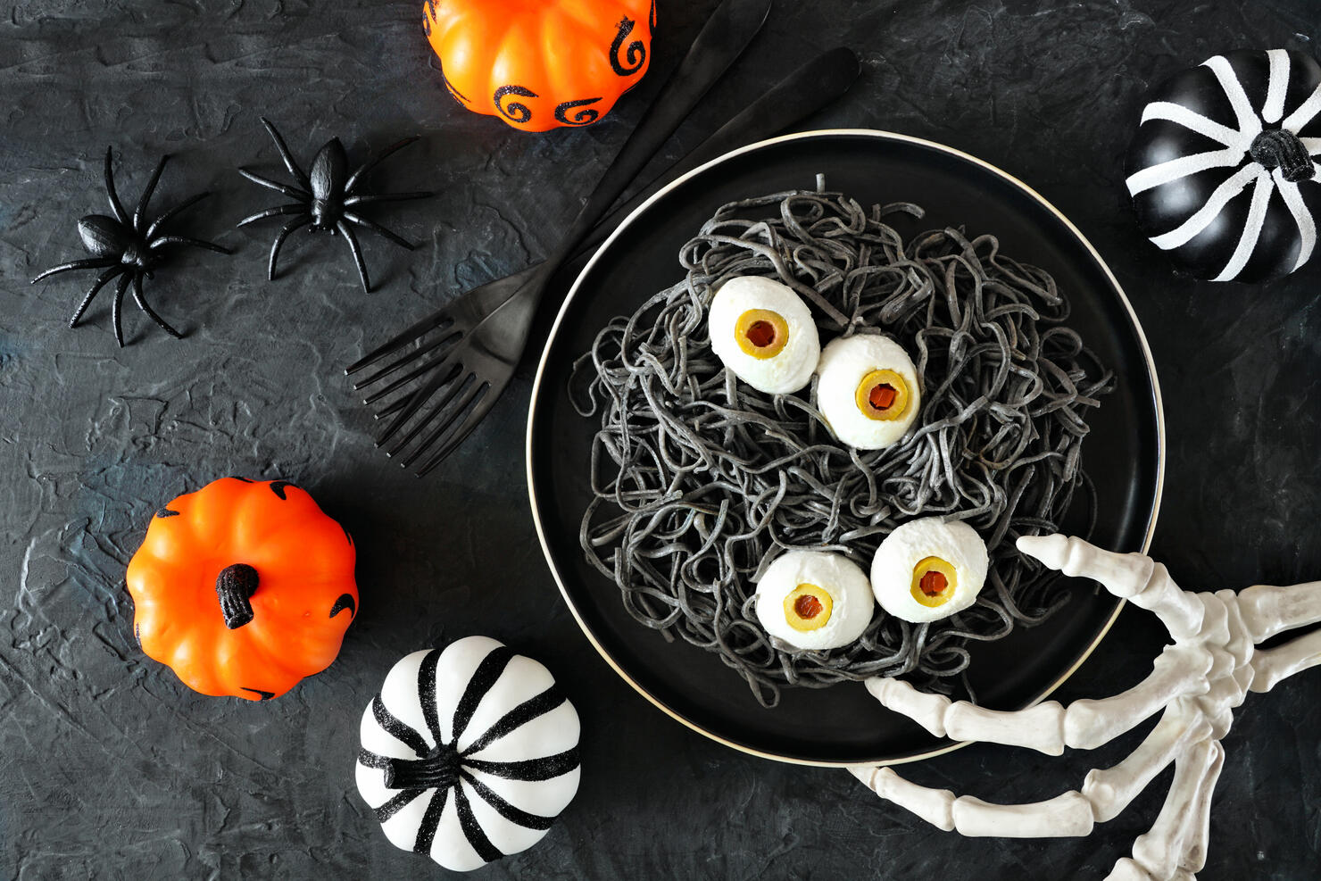Halloween eyeball spaghetti table scene over a dark background with orange, black and white decor