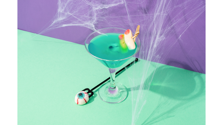 Scary colorful Halloween cocktails with party decorations on purple and green background
