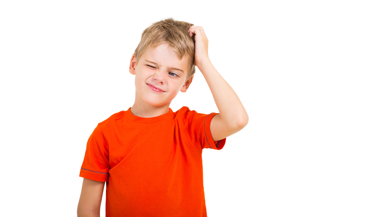 young boy scratching his head