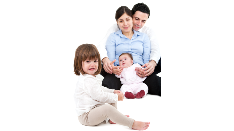 Unhappy jealous little girl with family