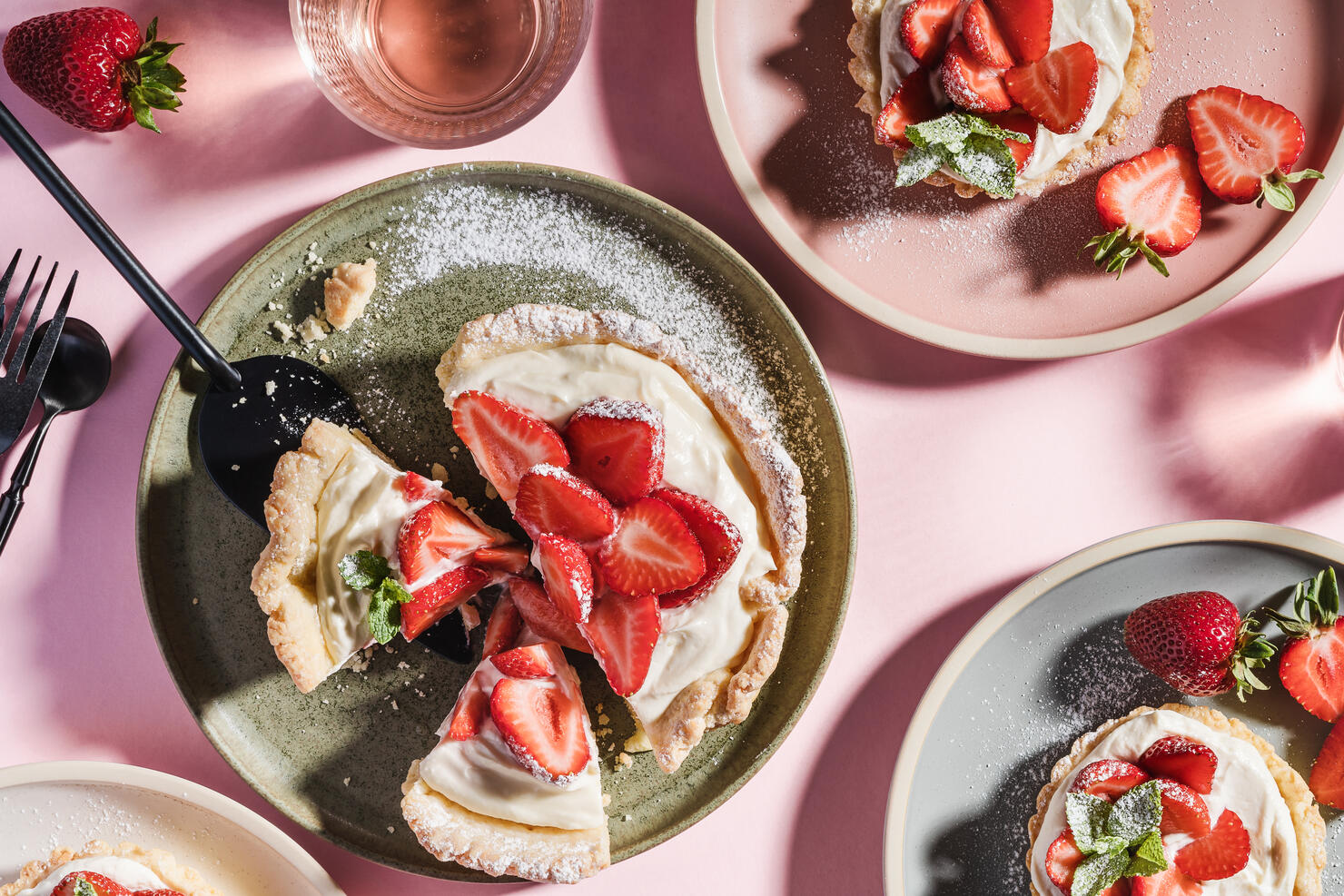 Summer sweet strawberry tarts on pink background with harsh shadows