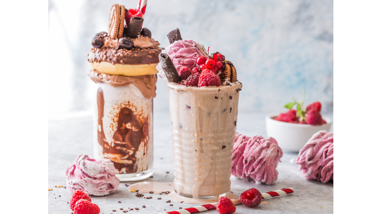 Chocolate indulgent frosting exreme milkshake with donut  and sweets. Crazy freakshake food trend. Copy space