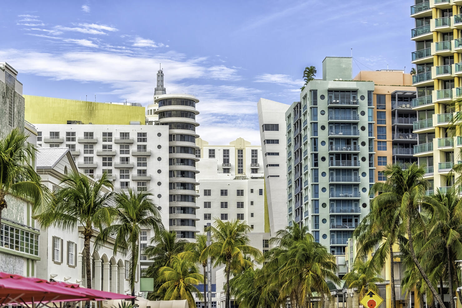 Miami South Beach Ocean Drive road street with famous retro art deco hotel colorful buildings cityscape with palm trees and blue sky on sunny day