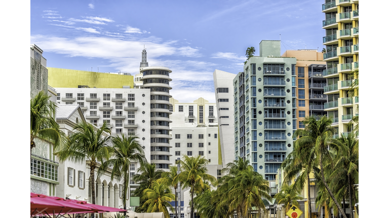Miami South Beach Ocean Drive road street with famous retro art deco hotel colorful buildings cityscape with palm trees and blue sky on sunny day