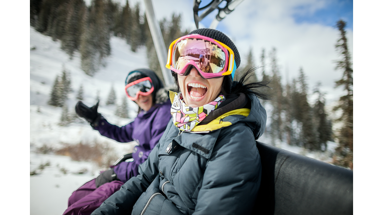 Girls laughing and having fun on a chair lift.